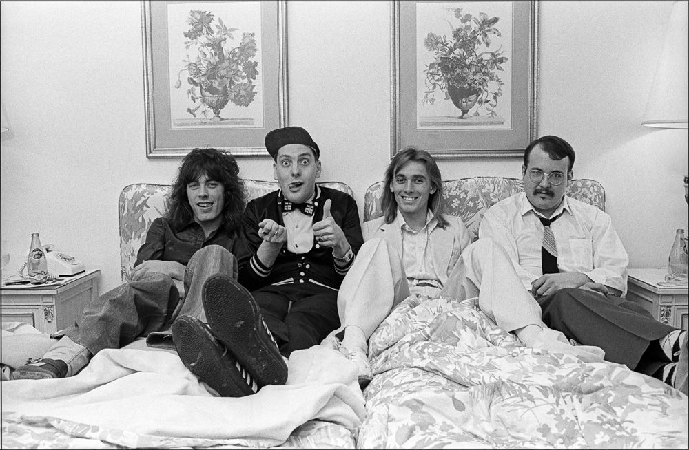 Tom Petersson, Rick Nielsen, Robin Zander, and Bun E. Carlos of Cheap Trick in their hotel room at the Park Lane after an interview, 1977. (Allan Tannebaum)